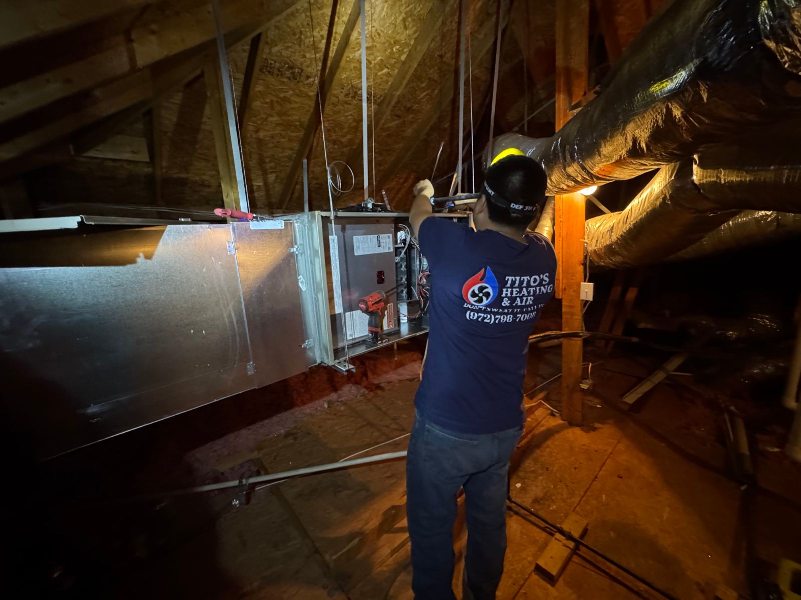 Tito's Heating and Air technician installing attic ductwork