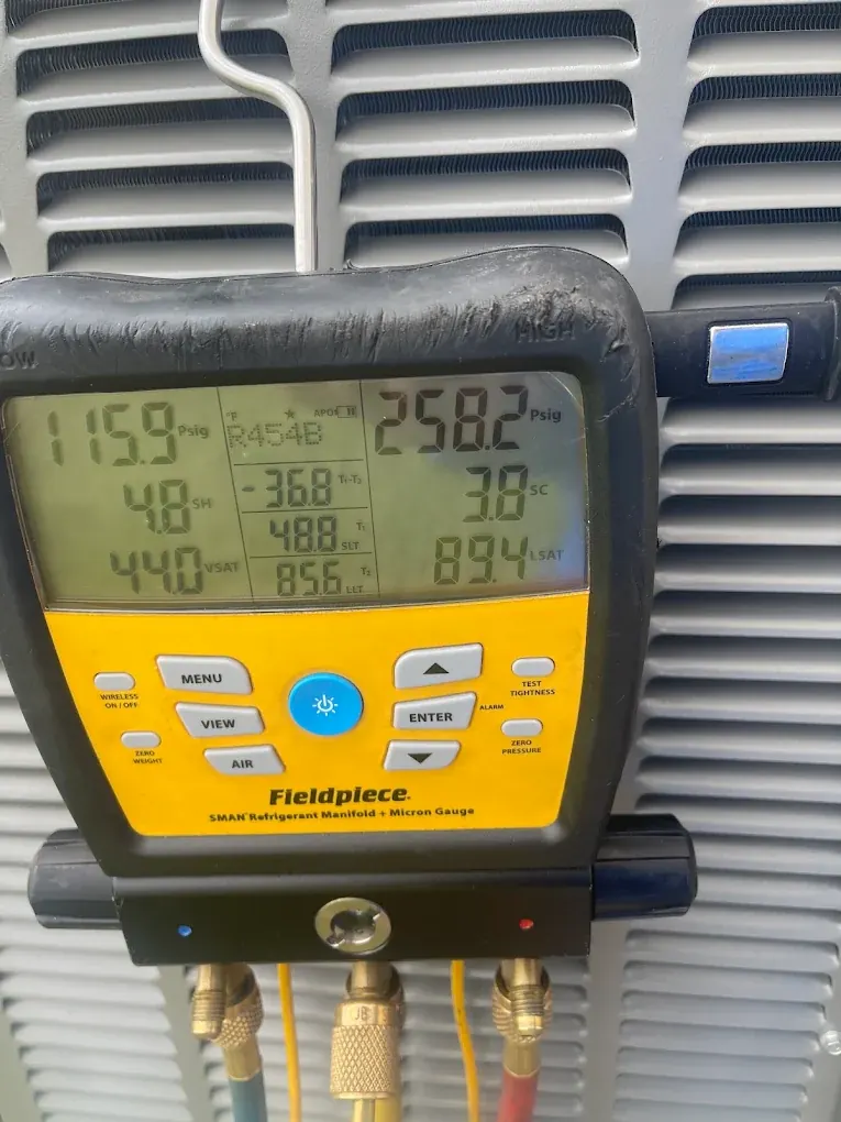 Tito's technician measuring HVAC refrigerant pressure with digital diagnostic gauges