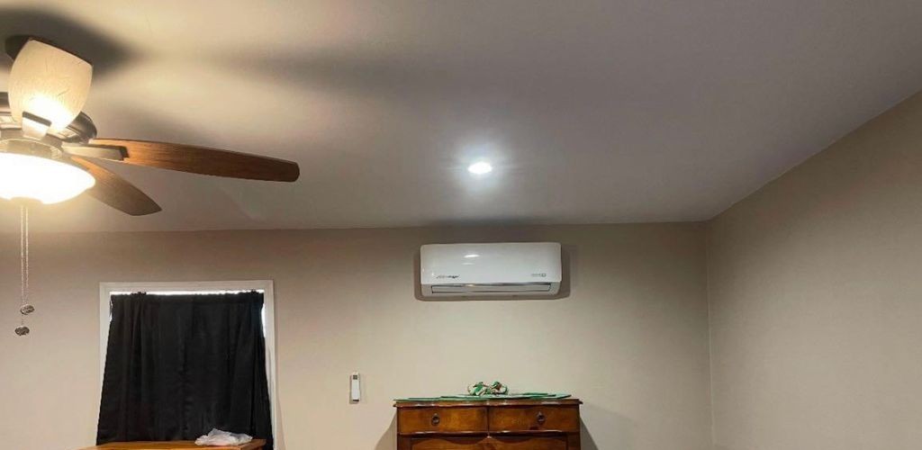 Ductless mini-split indoor unit mounted high on a bedroom wall
